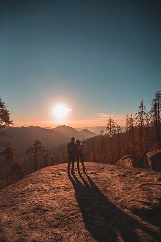 sequoia national park silhouette of man and woman on hill dirt road